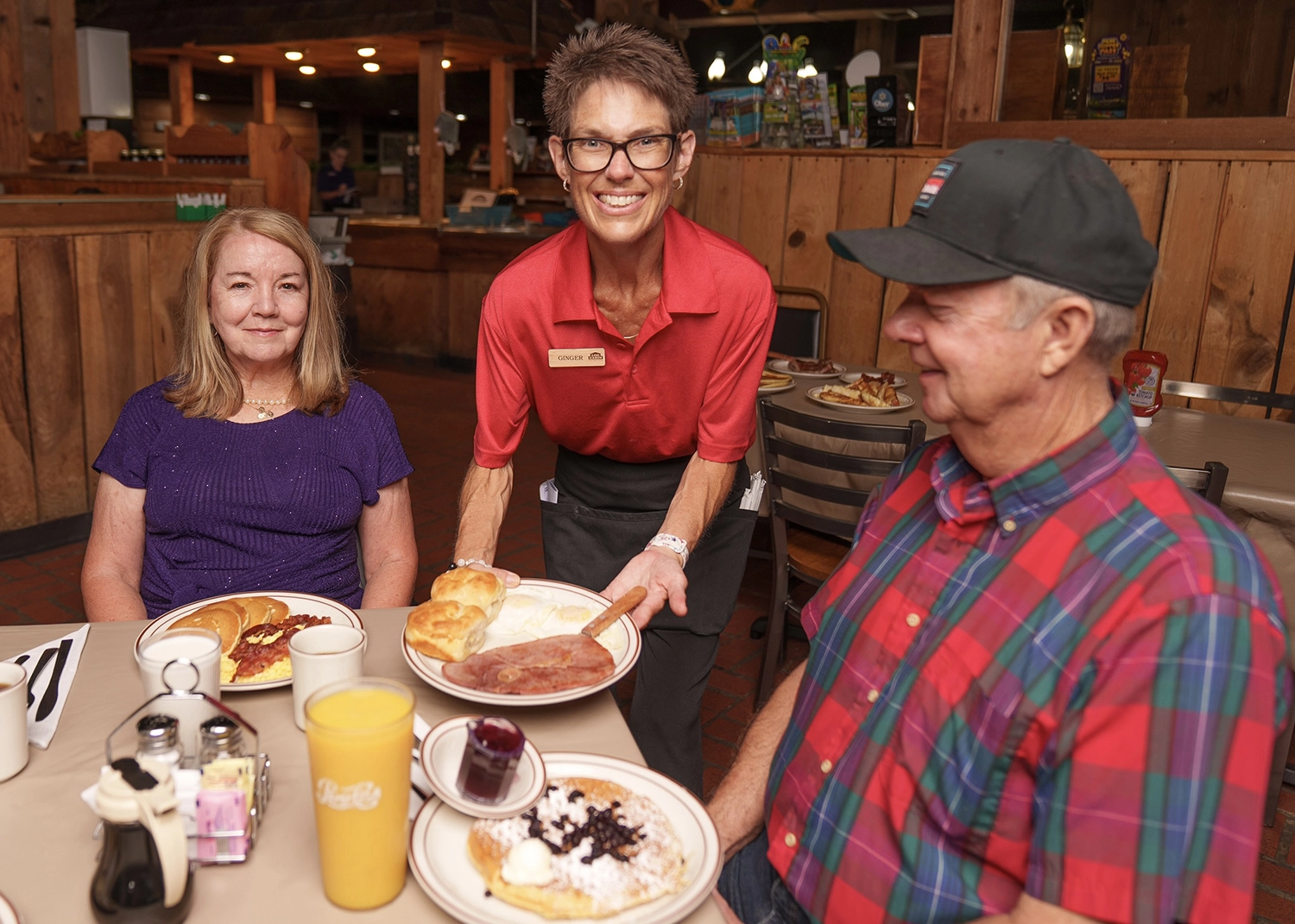 server placing food on table at Log Cabin Pancake House